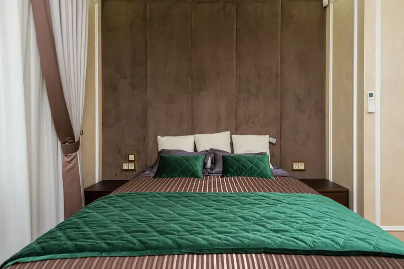 Cozy modern bedroom with green bedding and soft lighting. Ideal for contemporary design inspiration