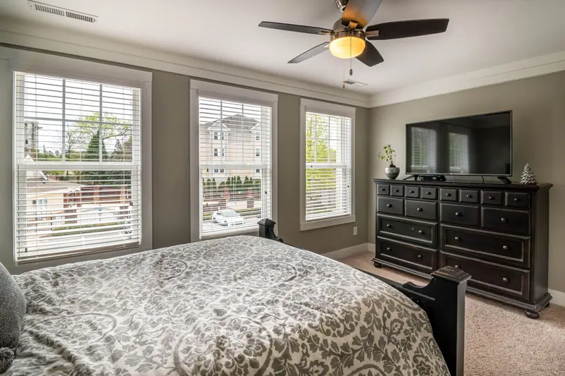 Spacious bedroom featuring elegant decor, modern furniture, and abundant natural light